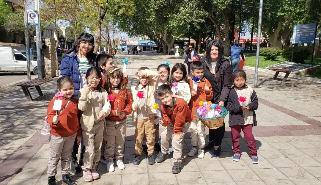 Alumnos de primer gado de la Escuela Gabriela Mistral recorrieron el centro de la ciudad, entregaron flores de papel a quienes pasaban por la plaza y enviaron cartas en el Correo a sus familiares